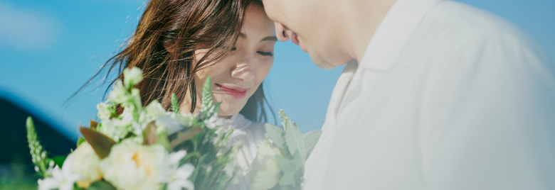 花束を間に挟み男女が向かい合っている様子